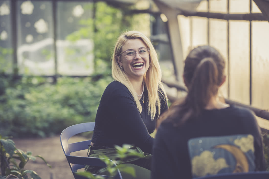 Caroline Uhl lacht im Gespräch mit einer Klientin